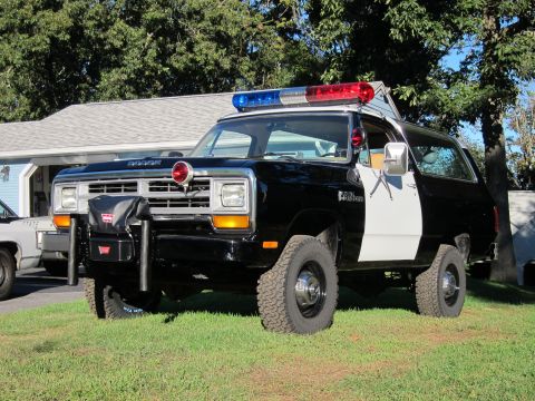 1987 Dodge 1500 - This police SUV is parked on a grassy lawn in front of a house.