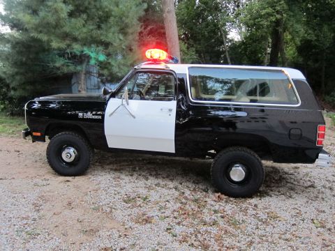 1987 Dodge 1500 - This 1987 Dodge 1500 is configured as a police SUV, a distinctive black and white paint scheme and a rooftop light bar.