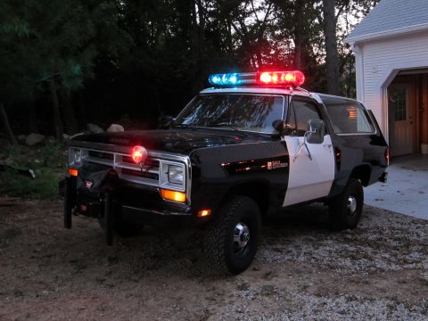 1987 Dodge 1500 - This police SUV has a light bar and siren, and appears to be a Dodge Ramcharger from the 1980s.