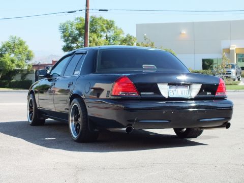 2003 Ford Crown Victoria - Passenger-rear view of a lowered black Crown Victoria showing dual tips and the EVIL VIC plate.
