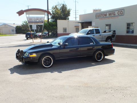 2003 Ford Crown Victoria - Driver-front angle of a black Crown Victoria wearing a steel push bar outside Custom Mfg Co.