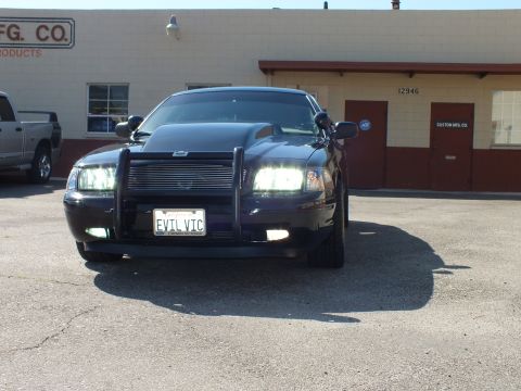 2003 Ford Crown Victoria - Head-on view of a black Crown Victoria with billet grille, push bar and EVIL VIC plate.
