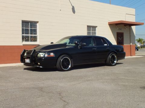 2003 Ford Crown Victoria - Driver-front angle of a lowered black Crown Victoria wearing a grille guard and California plate.