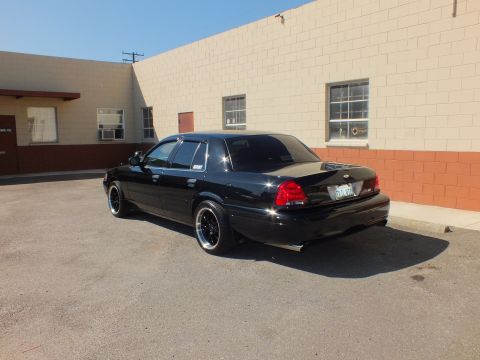 2003 Ford Crown Victoria - Rear view of a black Ford sedan with dual exhaust and a visible license plate.