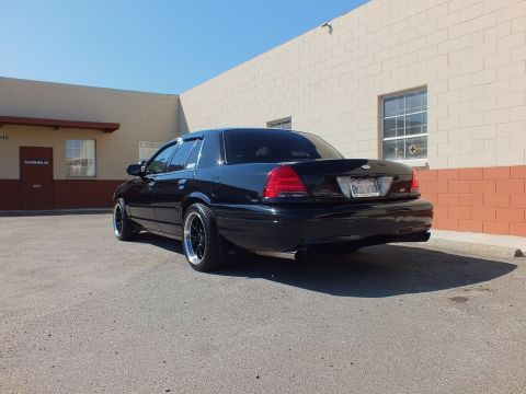 2003 Ford Crown Victoria - Rear three-quarter shot of a black Ford sedan with SVT trunk badge and dual exhaust.