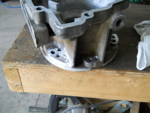 1992 Ford Bronco - A metal engine part rests on a wooden workbench next to a white cloth.