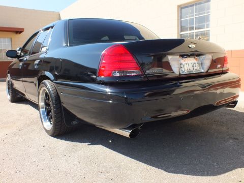 2003 Ford Crown Victoria - Close rear quarter showing Police Interceptor taillight script, SVT badge and dual exhaust.