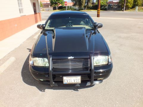 2003 Ford Crown Victoria - Front-on shot of a blacked-out Crown Victoria fitted with a police-style push bumper and EVIL VIC plate