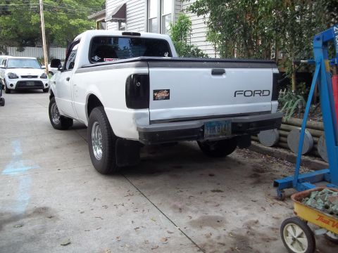 1970 Ford Ranchero - Rear view of a white Ford pickup truck with custom blacked-out taillights and "FORD" lettering on the tailgate.