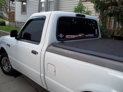 1970 Ford Ranchero - This white pickup truck is shown from the side, several stickers on its rear window.