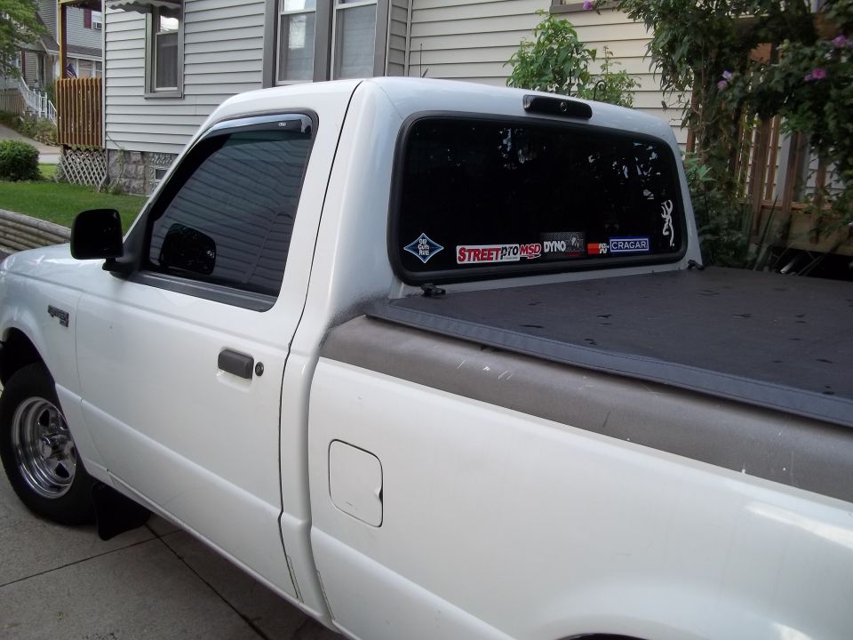 White pickup truck side view with stickers on rear window