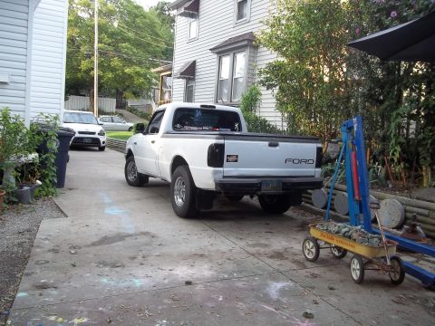 1970 Ford Ranchero - A white Ford pickup truck is parked in a driveway, with another white SUV visible in the background.