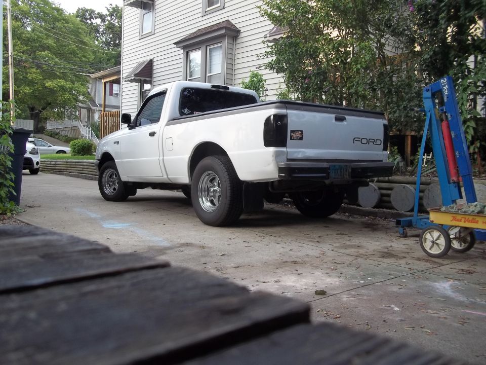 White Ford Ranger pickup truck parked in driveway, rear view. Ford logo visible on tailgate