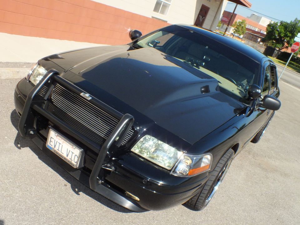 Black Crown Victoria front three-quarter with push bar and chrome wheels, EVIL VIC plate