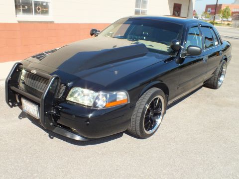 2003 Ford Crown Victoria - Front three-quarter view of a lowered black Crown Victoria with police push bar and dark machined-lip wheels