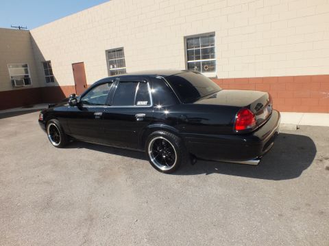2003 Ford Crown Victoria - Rear three-quarter of a black Panther-platform sedan, lowered with tinted glass and dark machined wheels