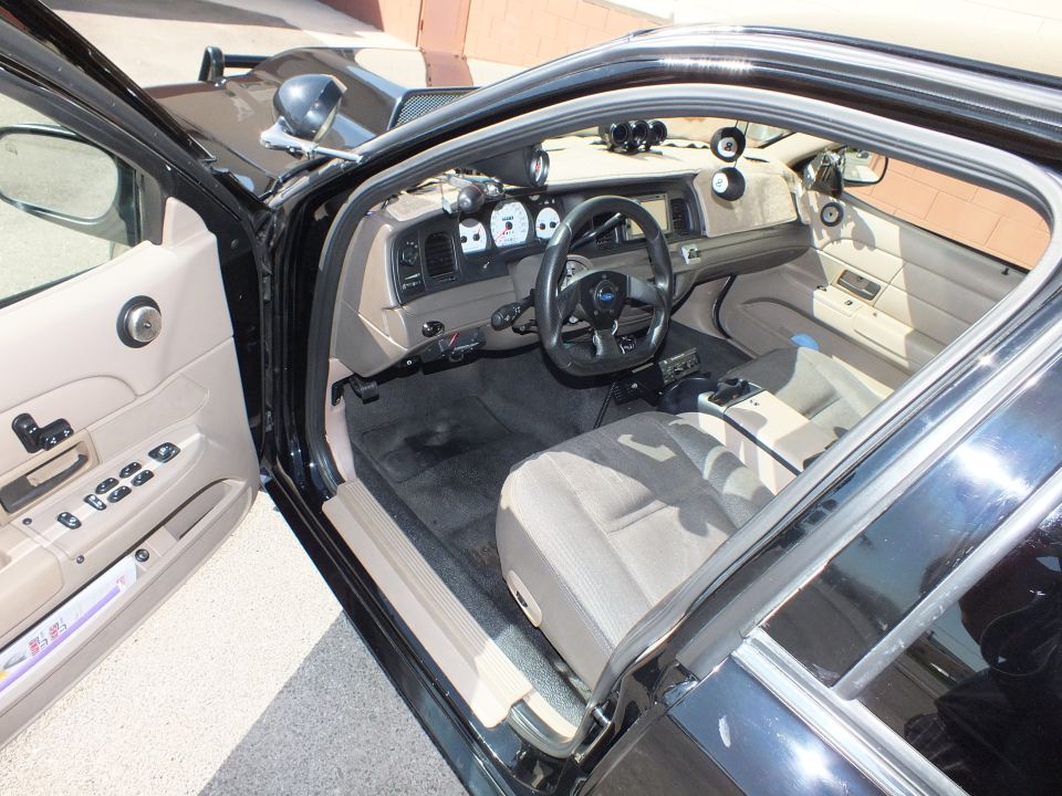 Tan interior of full-size sedan with custom three-spoke steering wheel and gauge pod