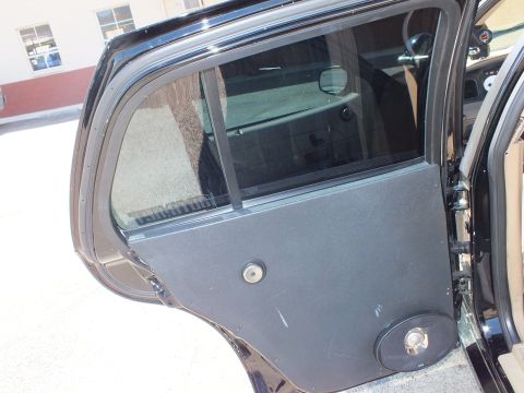 2003 Ford Crown Victoria - Open rear door showing a carpet-wrapped custom door panel with flush speaker and lock