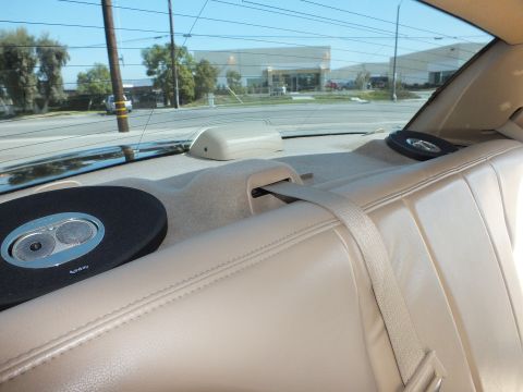 2003 Ford Crown Victoria - View across the rear deck showing dual coaxial speakers mounted in the parcel shelf above a tan seat