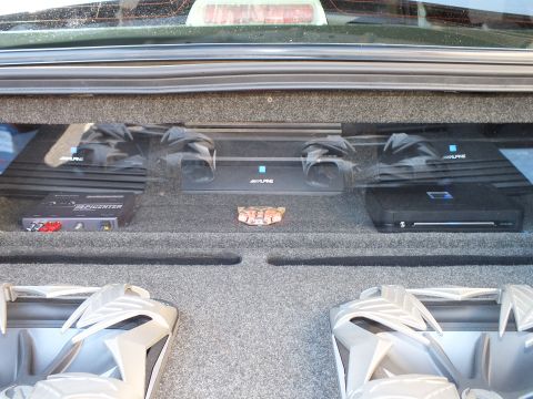 2003 Ford Crown Victoria - Amplifier rack featuring Alpine and Soundstream amps on a carpeted panel above two subwoofers