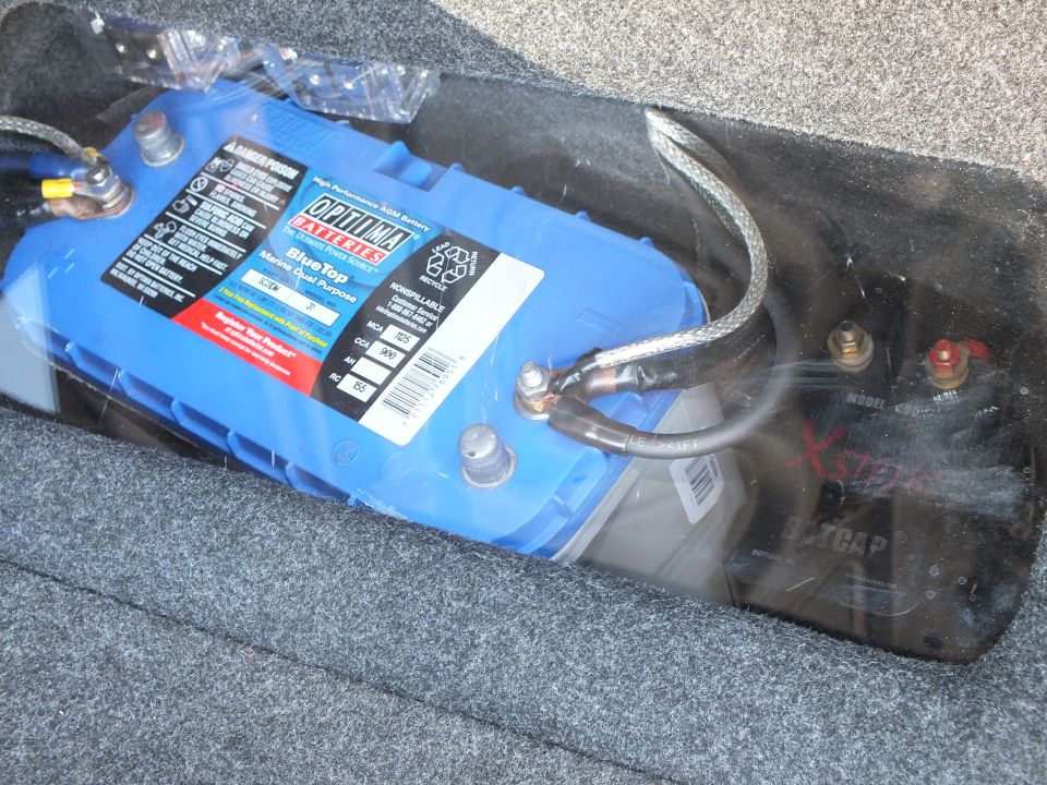 Blue Optima Blue Top battery mounted in carpeted trunk with cabling