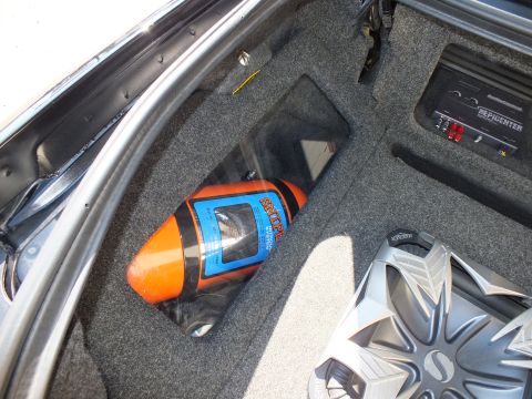 2003 Ford Crown Victoria - Trunk audio install showing an orange Stinger power capacitor next to a chrome Soundstream sub and amp rack
