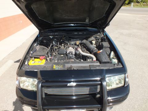 2003 Ford Crown Victoria - Under the hood of a black Crown Victoria showing the V8, air intake and a front push bar