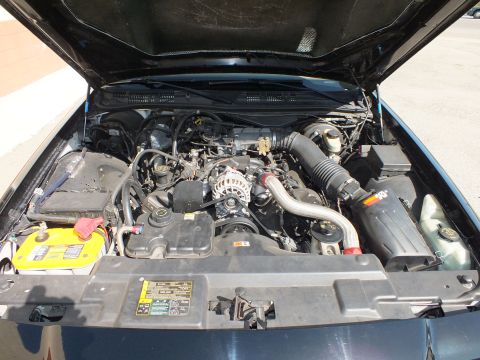 2003 Ford Crown Victoria - Detailed engine bay view of a sedan with a polished intake pipe and yellow top-post battery