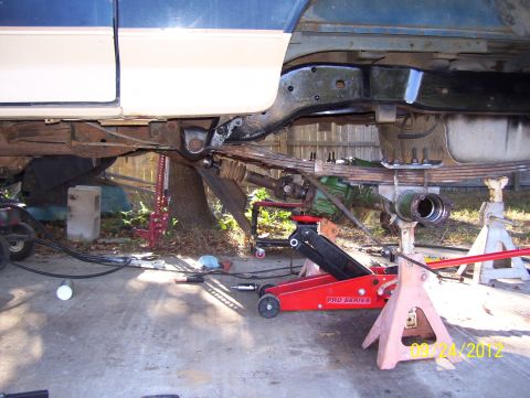 1990 Ford Bronco - Vehicle's rear axle and suspension components are visible while supported by jack stands.