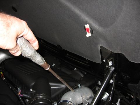 1995 Ford Bronco - Tool being used on a vehicle's engine intake pipe.