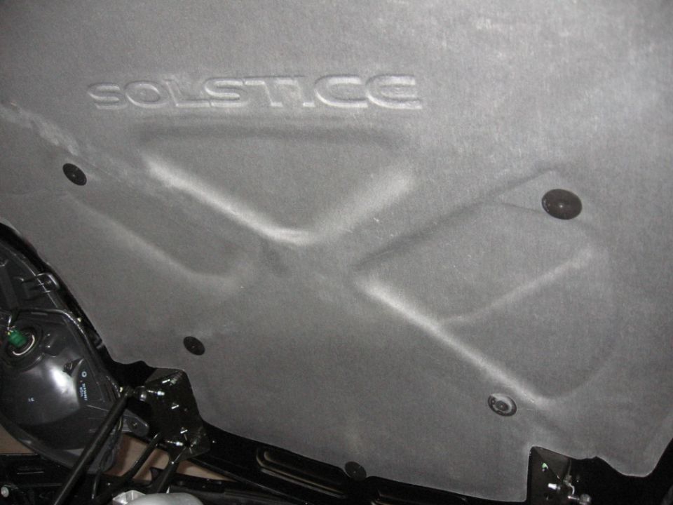 Underhood insulation with embossed "SOLSTICE" text. Black fasteners visible