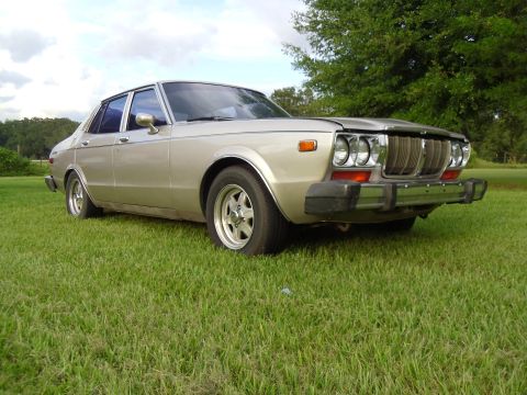 1978 Nissan Maxima - This 1978 Nissan Maxima is parked on a grassy lawn with trees in the background.