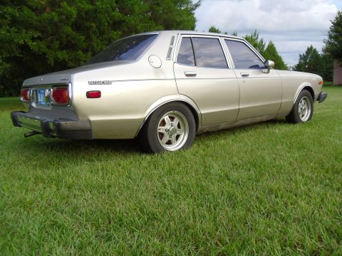 1978 Nissan Maxima - This 1978 Nissan Maxima sedan is seen from the rear 3/4 angle, parked on a grassy lawn.
