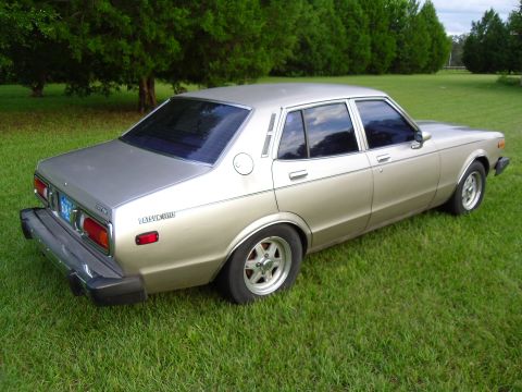 1978 Nissan Maxima - This 1978 Datsun 510 sedan is shown from the rear quarter angle, parked on a grassy lawn.