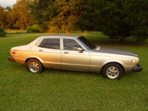 1978 Nissan Maxima - This 1978 Nissan Maxima is parked on a grassy lawn with trees behind it.
