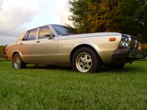 1978 Nissan Maxima - This 1978 Nissan Maxima sedan is shown from a 3/4 front angle, parked on a grassy area.
