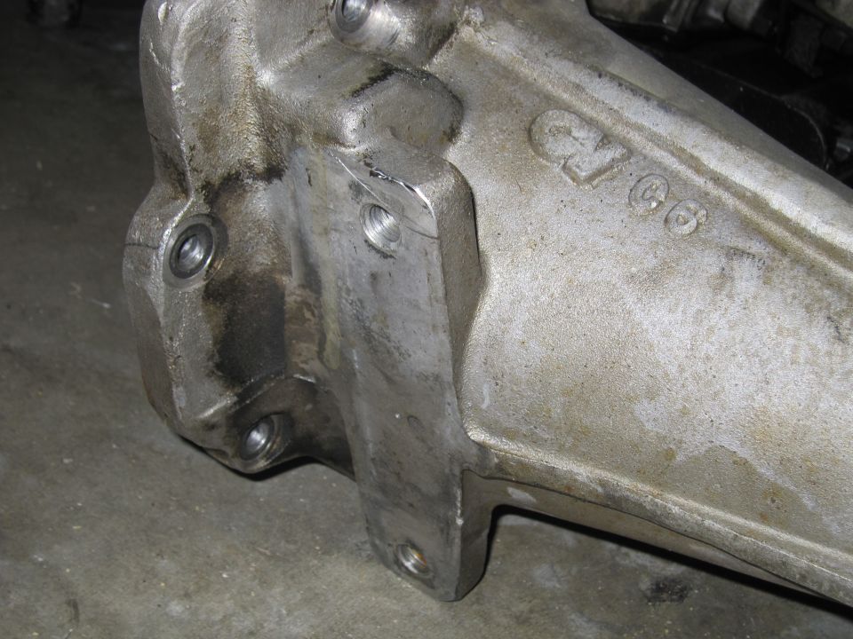 Close-up of a cast metal automotive part with 'C/66' stamped on it
