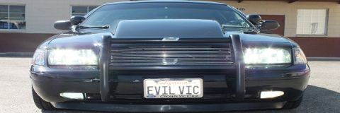 2003 Ford Crown Victoria - Head-on view of a blacked-out Crown Victoria, push bar and EVIL VIC plate with lights illuminated