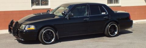 2003 Ford Crown Victoria - Profile of a lowered black Crown Victoria showing the front push bar and dark wheels