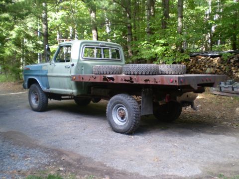 1979 Ford Bronco - A vintage Ford F-250 flatbed truck with a two-tone paint job sits outdoors.