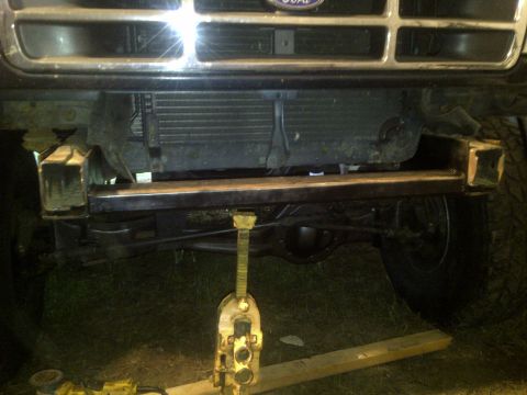 1995 Ford Bronco - The front of a Ford truck is shown with a jack supporting the frame and the radiator exposed.