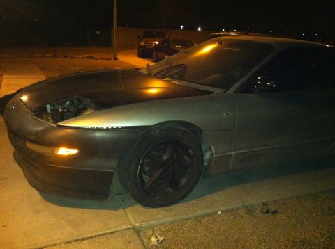 1993 Ford Probe - A silver 1993 Ford Probe sits parked at night with its hood open, revealing the engine compartment.