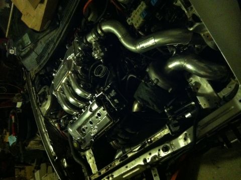 1993 Ford Probe - Close-up view of a modified engine bay, highlighting the polished exhaust and intake system.