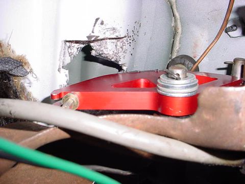 1991 Ford LTD Crown Victoria - Close-up of a red metal bracket with hardware and wiring, attached to a rusty surface.