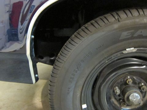 1991 Ford LTD Crown Victoria - Close-up of a dark blue wheel well and tire, showing the tire size and chrome trim detail.
