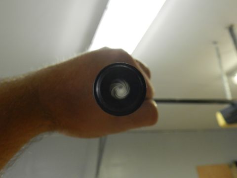 1996 Ford Bronco - The aperture blades of a camera lens are visible as the hand holds it up.