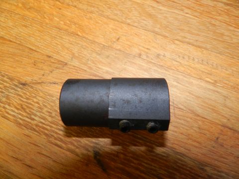 1996 Ford Bronco - A close-up view of a black metal automotive part with visible set screws against a wooden background.