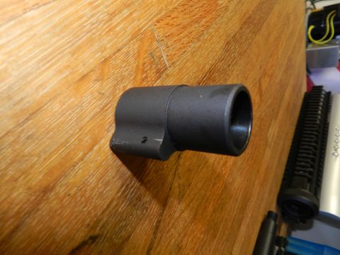 1996 Ford Bronco - A close-up view of a black gun barrel component resting on a wooden surface, with other parts visible in the background.