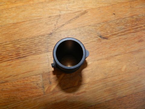 1996 Ford Bronco - A black metal pipe fitting with a clamp screw is shown on a wooden floor.