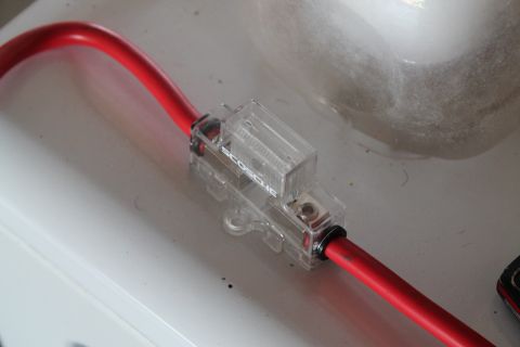 1990 Ford Bronco - Close-up of an in-line fuse holder connected to a red wire, with 'ECOSOUL' visible on the casing.